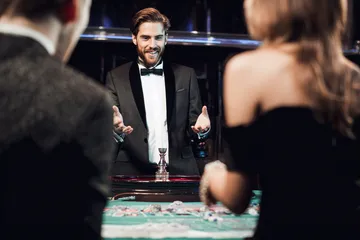 A professional dealer in a tuxedo greeting players at the roulette table, symbolizing the authentic live casino feel at CT44.