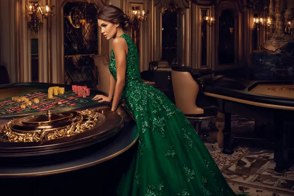 A woman in a luxurious green gown next to an ornate roulette wheel, capturing the upscale casino mood of CT44.